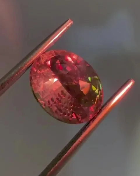 A mesma alexandrita natural na luz incandescente, com cor vermelha